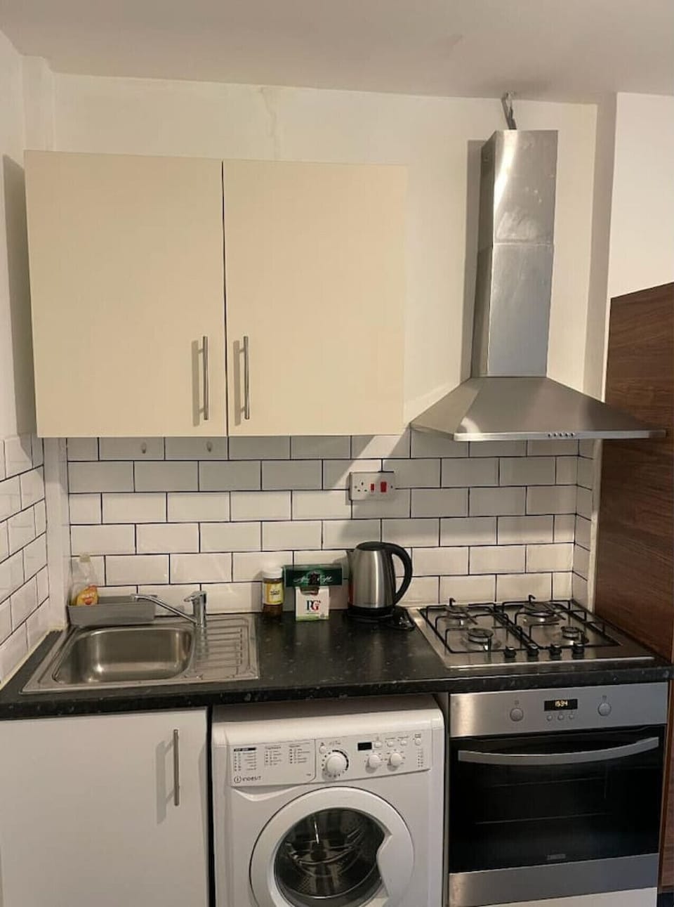 Compact kitchen with oven, hob, and washing machine