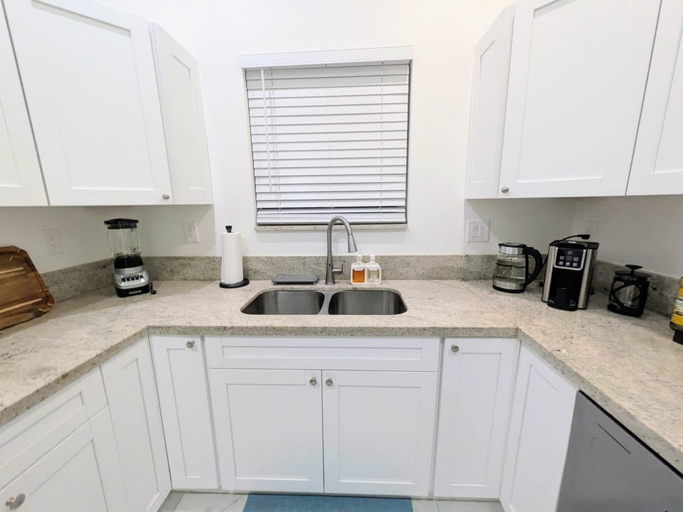Spotless sink with soaps, fresh sponge & modern fixtures.