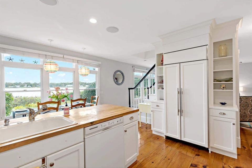 Modern, open kitchen with abundant counter space and panoramic views of Town Cove, a true centerpiece of this Orleans vacation rental