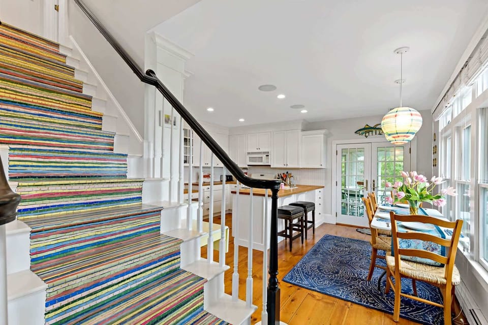 Distinctive painted stairs lead to the second level, adding a touch of coastal personality to this Cape Cod home