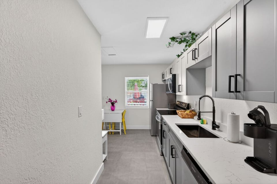 Streamlined kitchenette sink area w/ modern finishes for quick cleanups