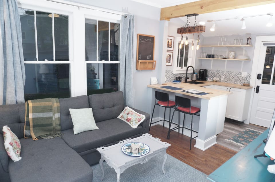 Cozy open living space with modern kitchen, bar seating, and comfy sofa setup