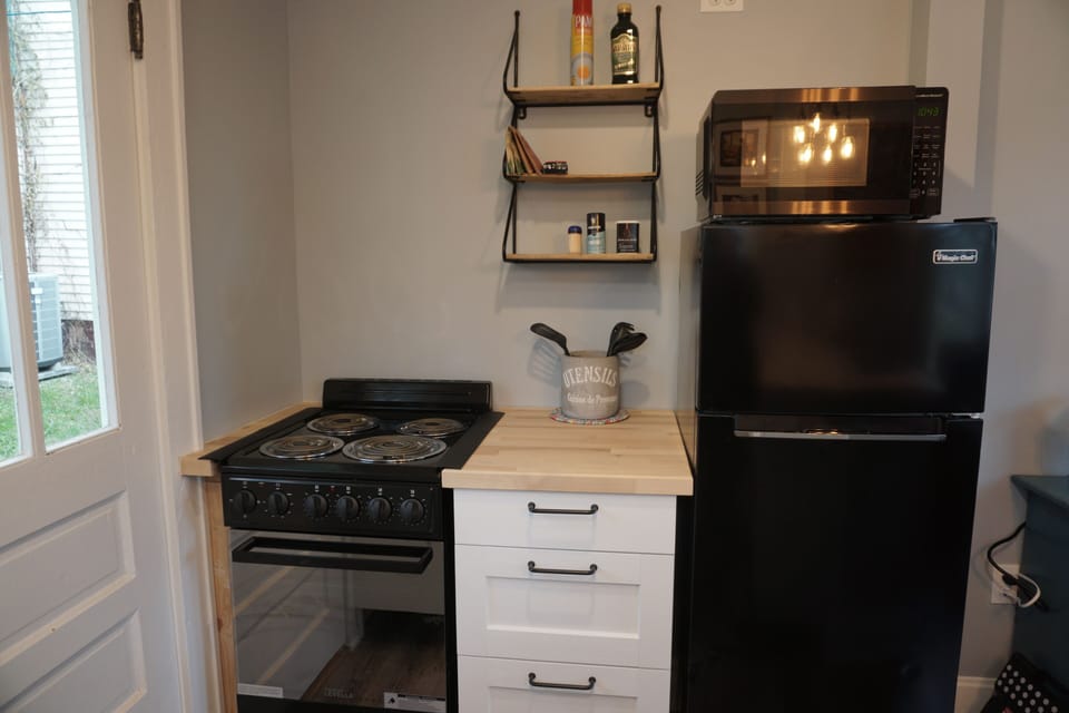 Fully equipped mini kitchen with stove, fridge, and butcher-block counters