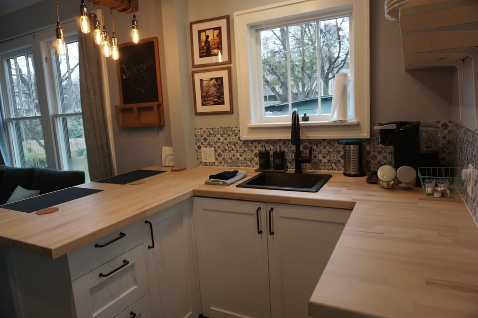 Cozy kitchen with butcher block counters, open shelves, and natural lighting