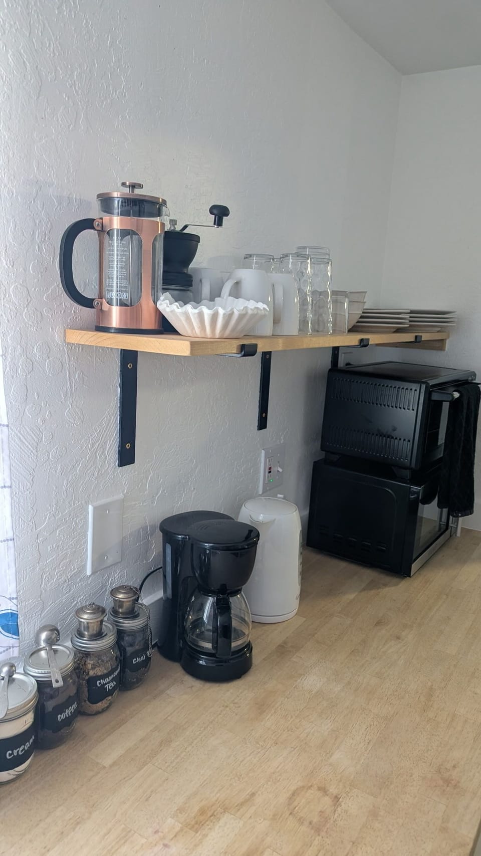 Coffee station with drip coffee, French press, mugs, and essentials