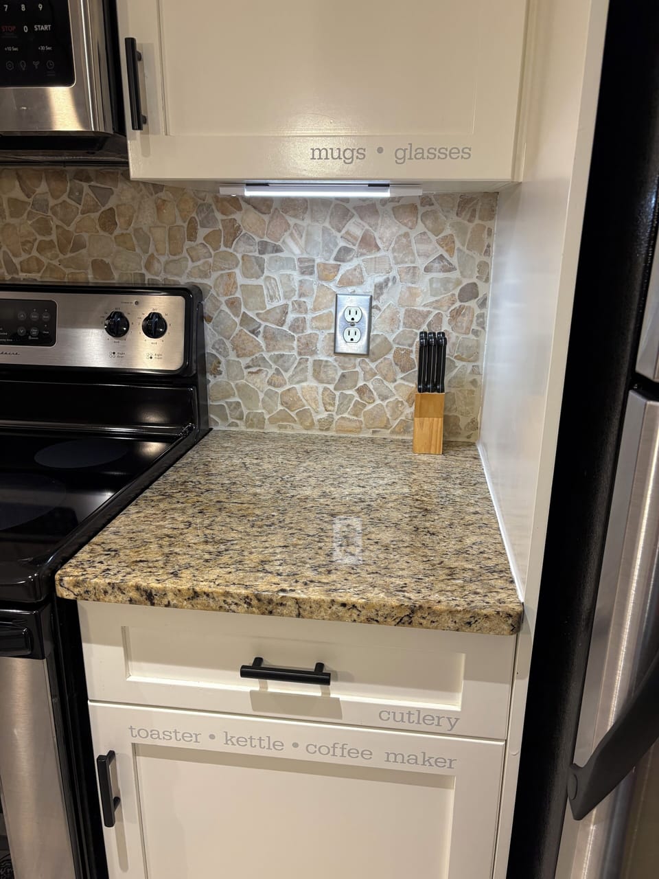 Kitchen cupboards are labelled for ease of navigation.