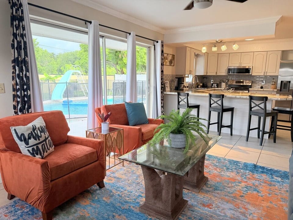 Sunset-safari living room with `Hakuna Matata` vibes. Oversized windows open to your private pool + slide. Lion King touches meet modern comfort.