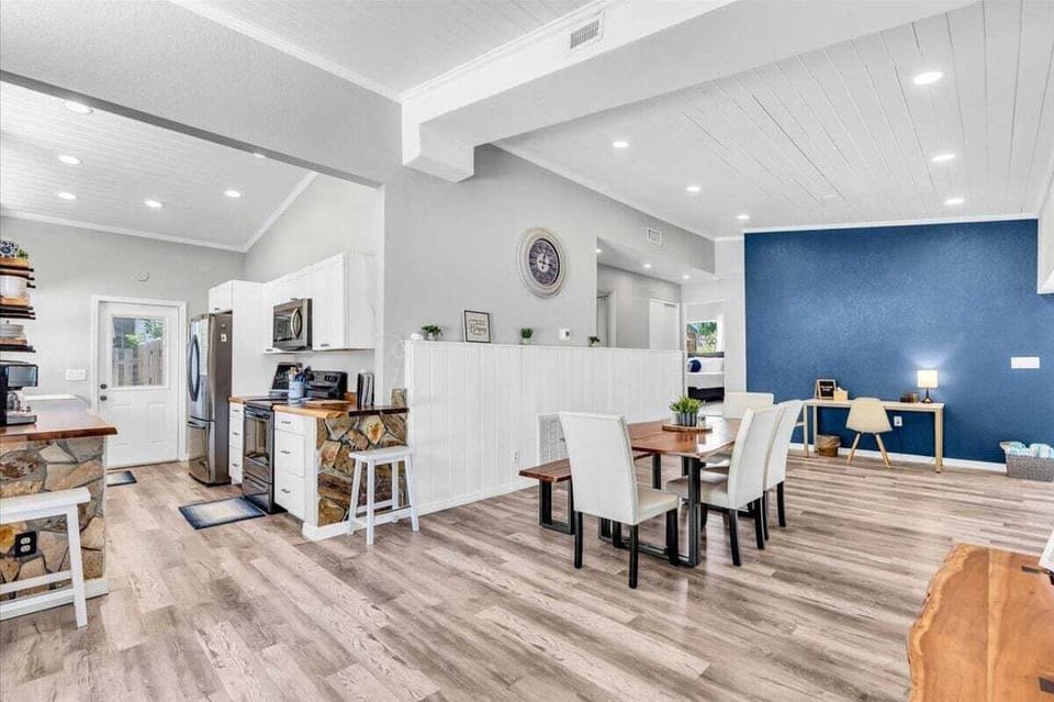 Dining area with four chairs and a bench, connected to the kitchen.