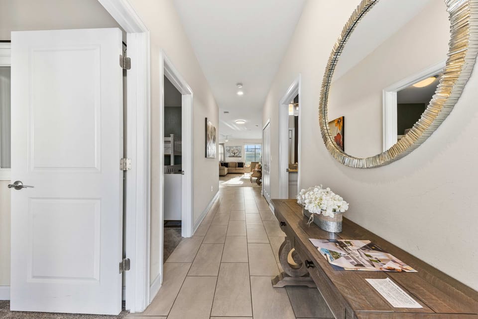 Airy entrance with stylish console and round mirror leads to the open living area-plus a peek at the bunk room with twin-over-twin beds.