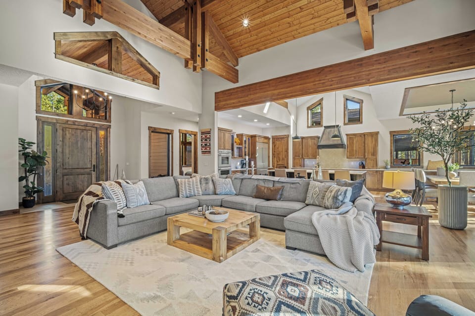 Sink into this expansive sectional beneath soaring timber beams, where your mountain retreat blends rustic charm with modern comfort in perfect harmony.