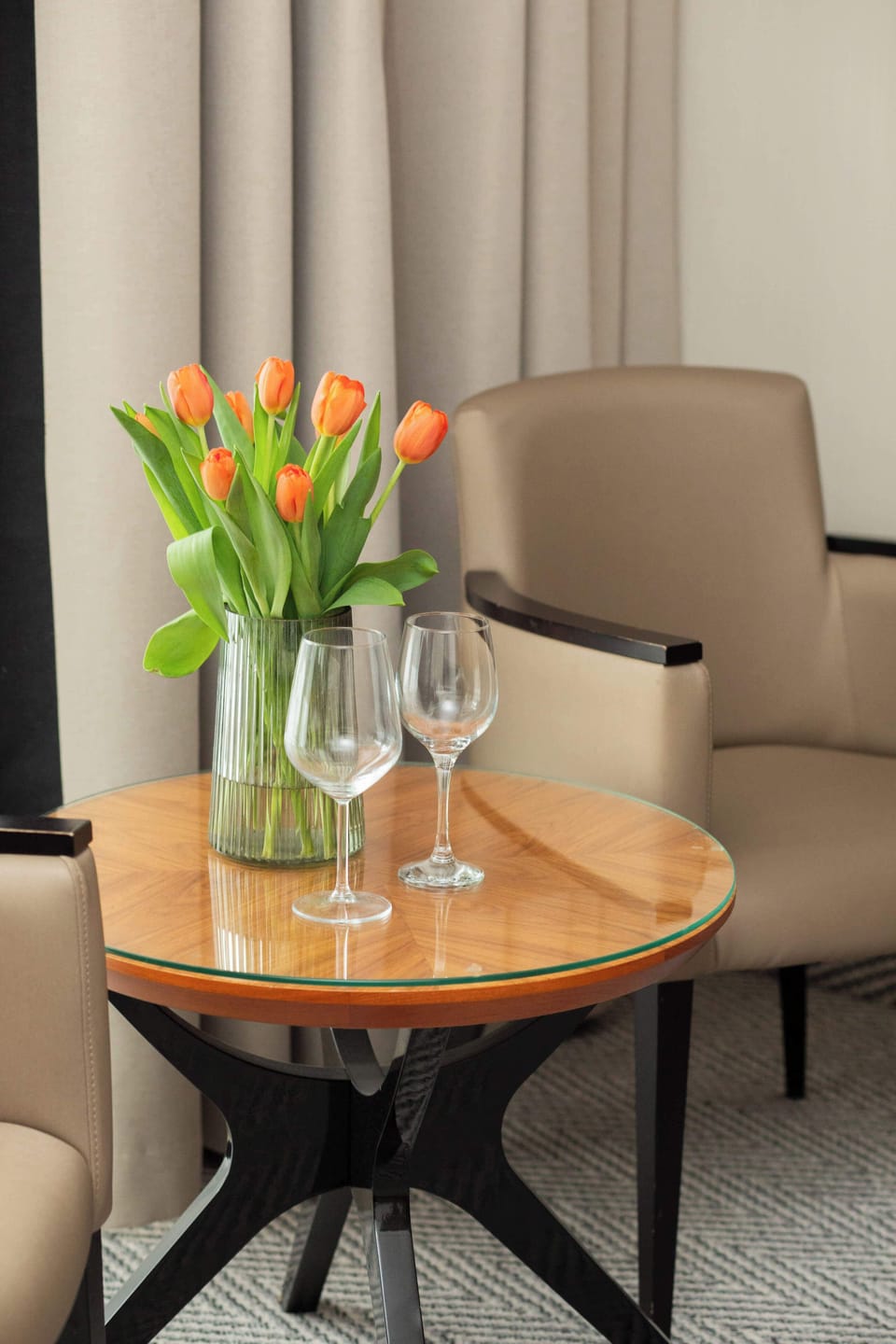 A small lounge corner within the studio furnished with elegant armchairs and a table, designed for comfort and relaxation.