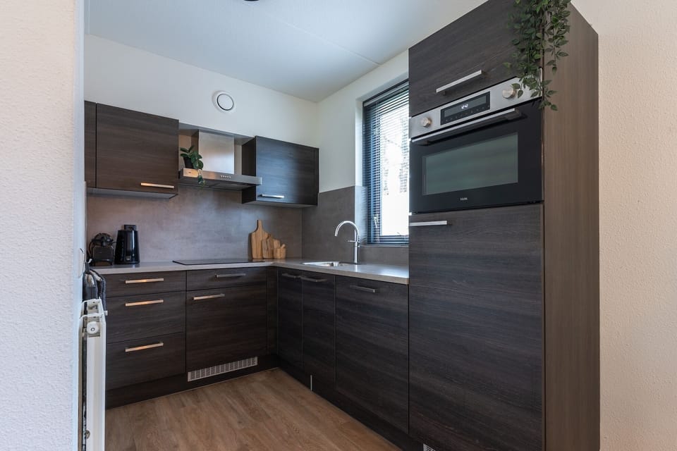 Modern kitchen with oven, microwave, stove, fridge/freezer, dishwasher, and full cookware — ideal for self-catering stays at Groenenheuvels House.