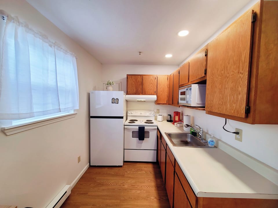 Fully equipped kitchen with stove, fridge, microwave and coffee maker 