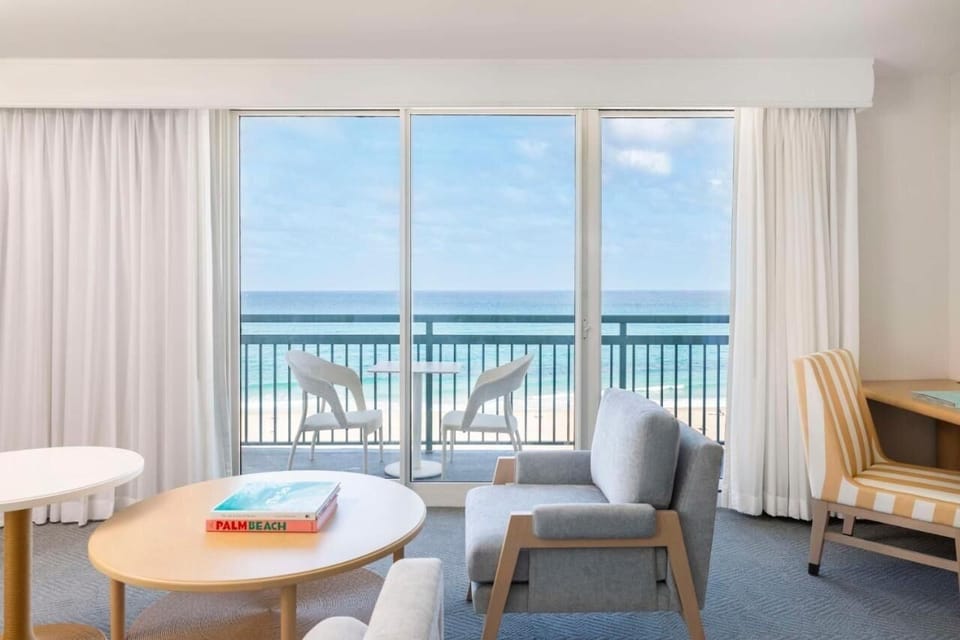 Lounge by the sliding doors with breezy beachfront scenery.