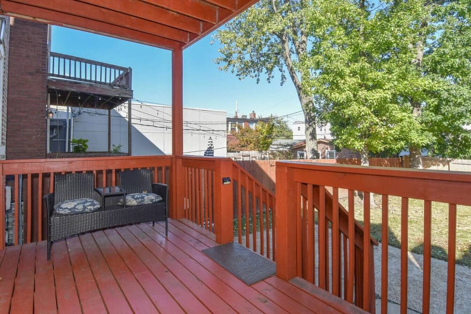 Spacious covered deck with stairs leading to the fenced backyard