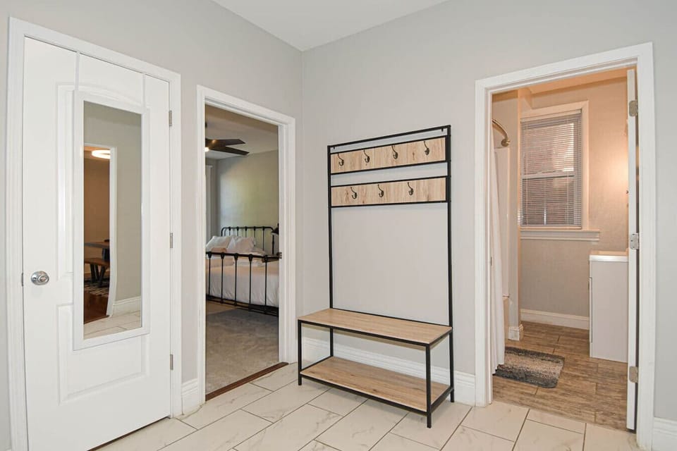 Bright entry hallway with tiled floors, bench seating, and wall hooks for coats and bags