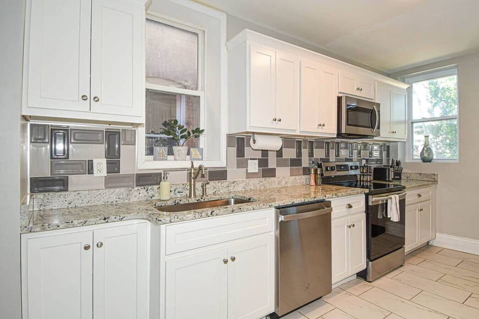 Fully equipped kitchen with stainless steel range, microwave, toaster, and cookware