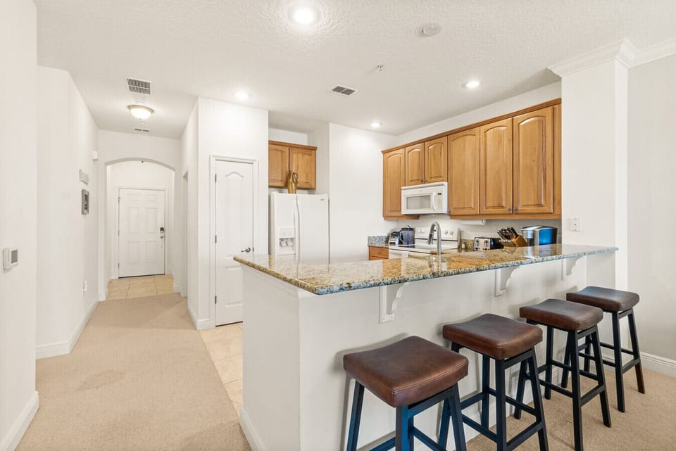 Fully equipped kitchen with stainless appliances and bar seating — everything you need for easy vacation cooking or a morning coffee.