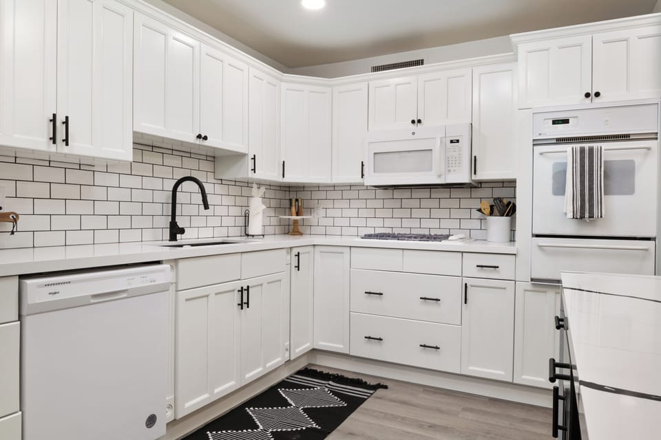 Stylish chef’s kitchen with marble island and subway tile.