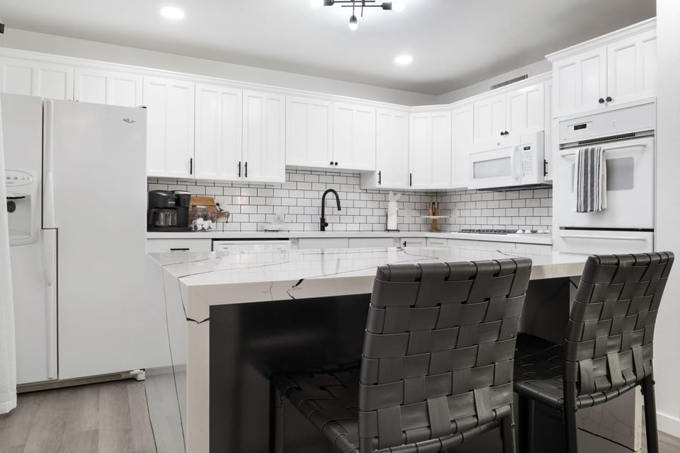 Fully equipped white kitchen perfect for home-cooked meals.
