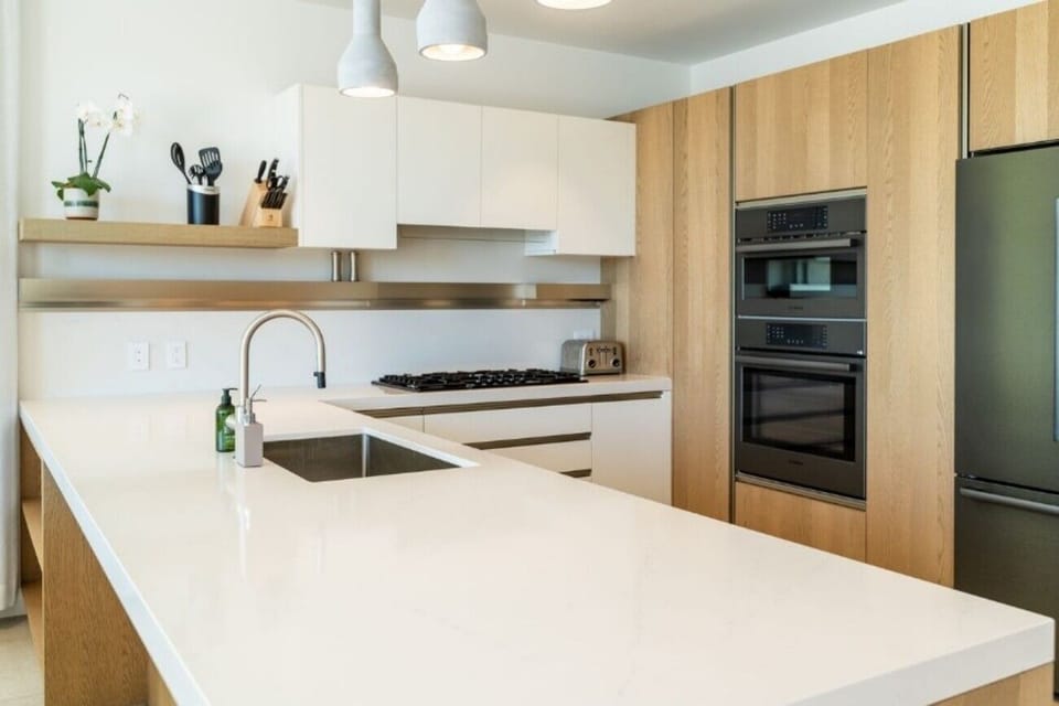 Prep fresh breakfasts on sleek counters under warm pendant lights.
