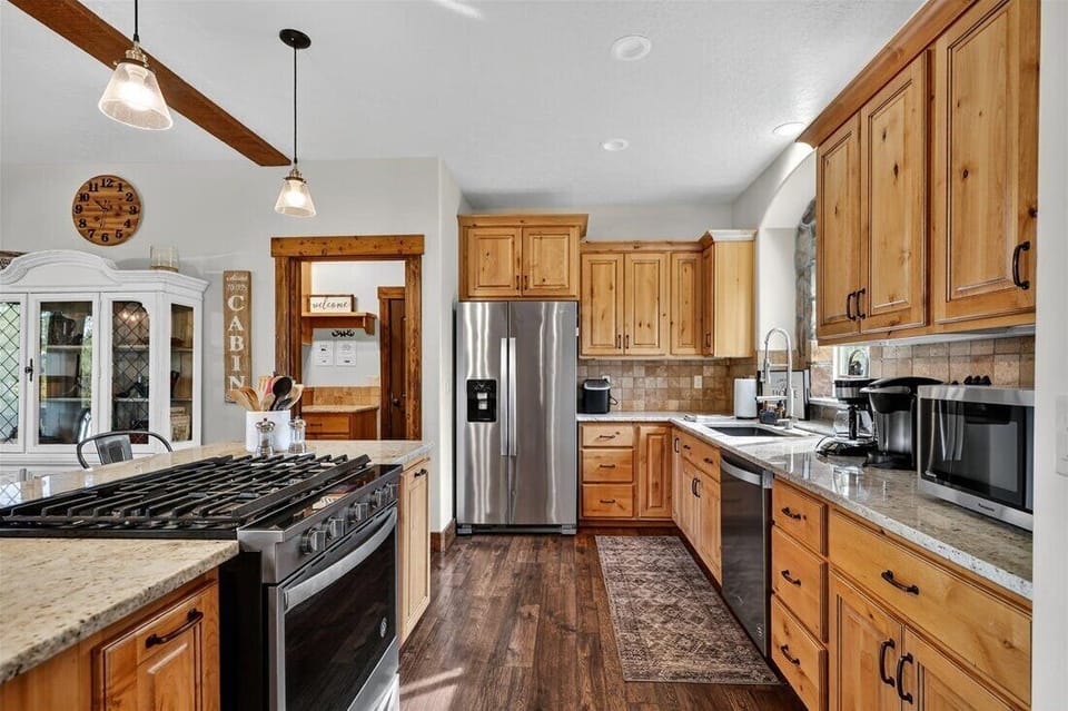 Bright kitchen with granite counters and forest-view dining.