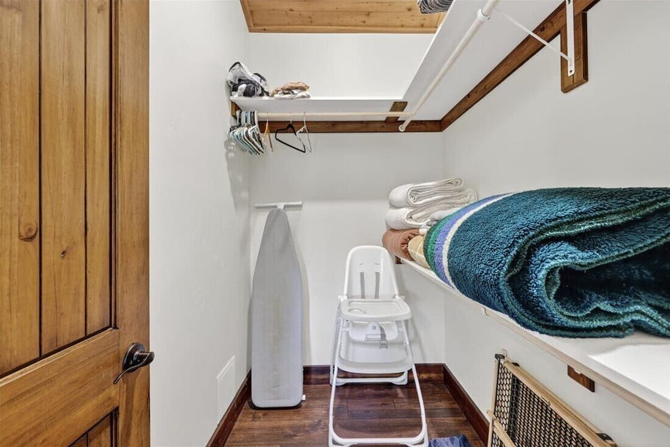 Well-stocked closet with linens and ironing essentials.