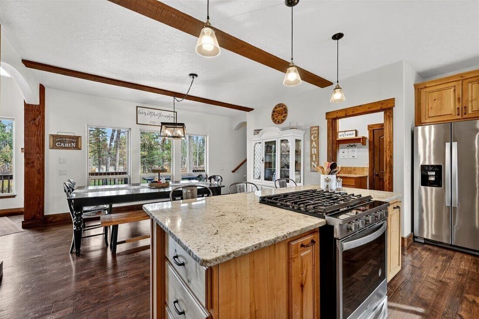 Bright kitchen with granite counters and forest-view dining.