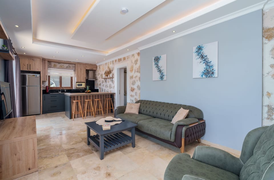 Open plan lounge and kitchen with patio doors to pool and view