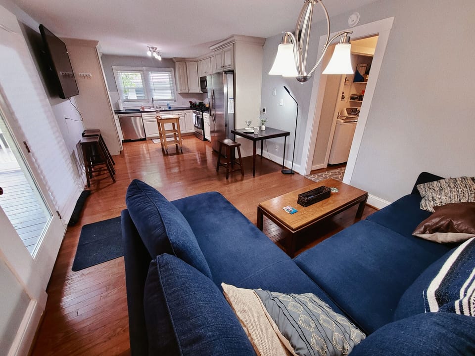 Modern open lay-out living space with comfy sofa, dining area, and kitchen.