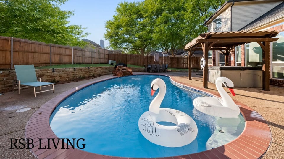 This backyard oasis features a sparkling swimming pool surrounded by a deck, perfect for lounging. A pergola provides shade for the hot tub, and the fenced yard ensures privacy. Ideal for relaxation and fun!