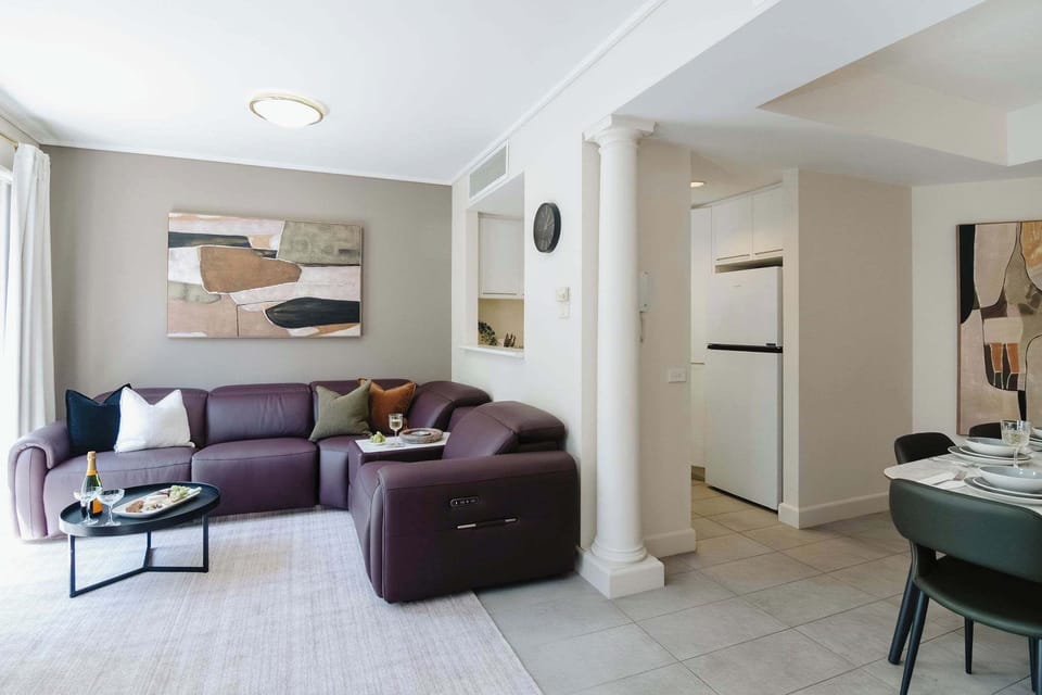 Settle into the elegant living room with a six-seater reclining leather sofa, cosy coffee table, and balcony doors that invite the northern light in.