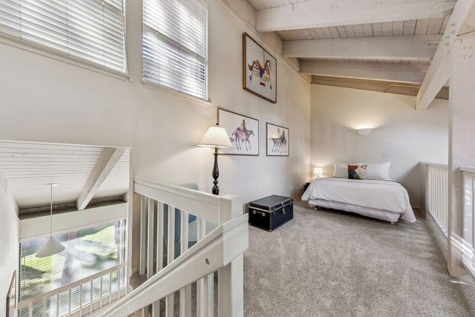 Your cozy loft bedroom awaits with exposed beams, soft carpeting, and charming vintage touches creating a peaceful retreat.