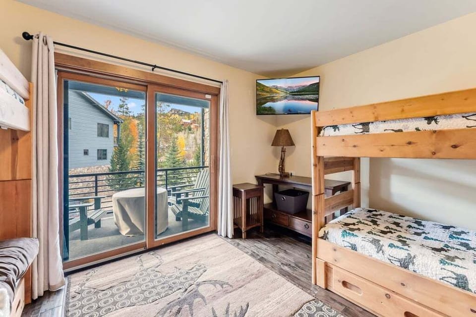 Cozy bunk room with autumn mountain views from your private balcony—perfect for family adventures and relaxing evenings.