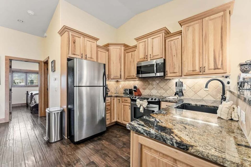 Your fully equipped kitchen awaits with granite counters, stainless steel appliances, and warm wood cabinetry for memorable meal prep.