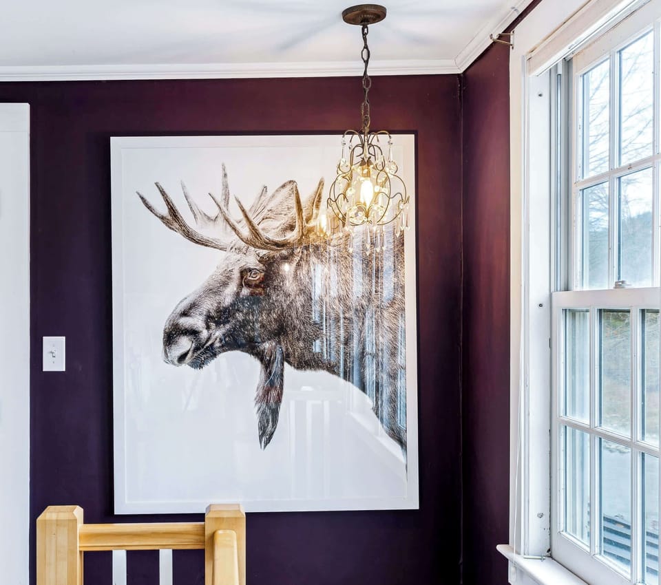 Vintage moose art and chandelier add New England character