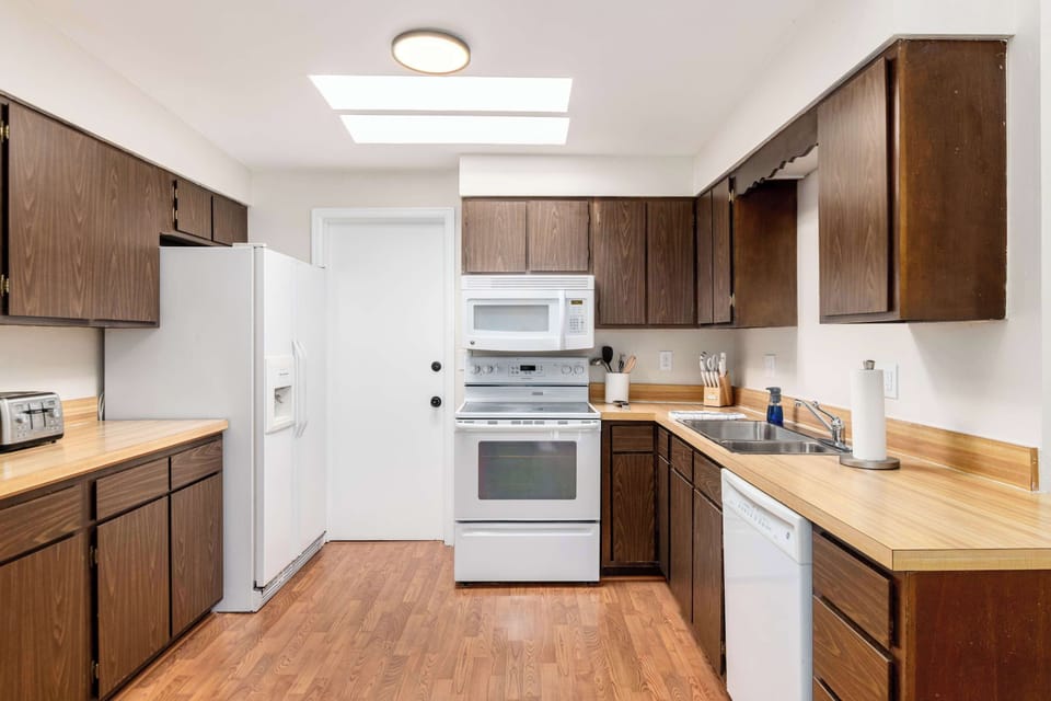Fully stocked kitchen featuring sleek wood cabinetry.