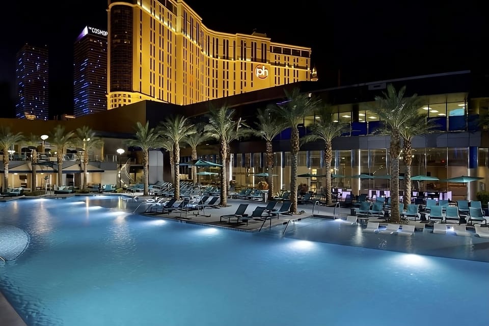 Soak up resort vibes with a glowing pool under palms.
