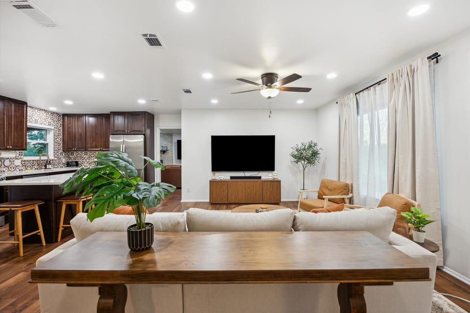 Spacious living room with 75" TV, soundbar, and comfy L-couch seating.
