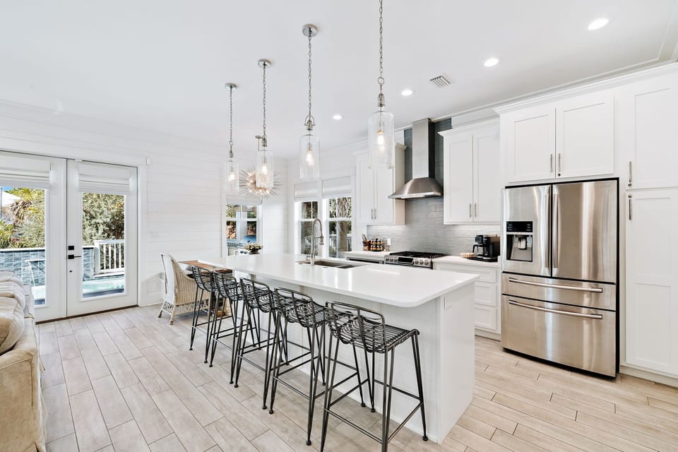 Beautiful kitchen featuring a large island, stainless steel appliances, ample seating, and fully stocked with all your essentials.