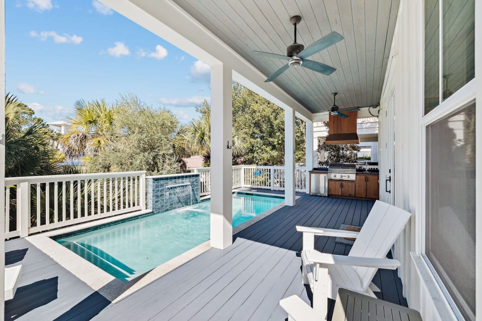 Private outdoor pool area conveniently located just outside the living room and kitchen, featuring a heated pool with a beautiful waterfall, seating and loungers, plus an outdoor grill and kit