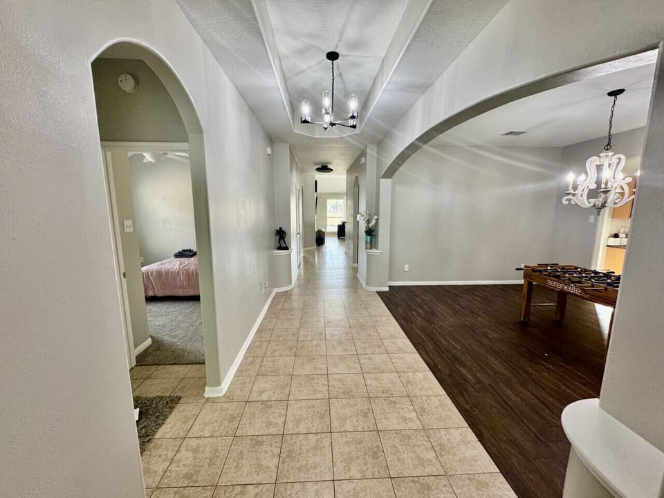 Wide, welcoming hallway leading to bright open spaces — perfect for family gatherings and fun nights in.
