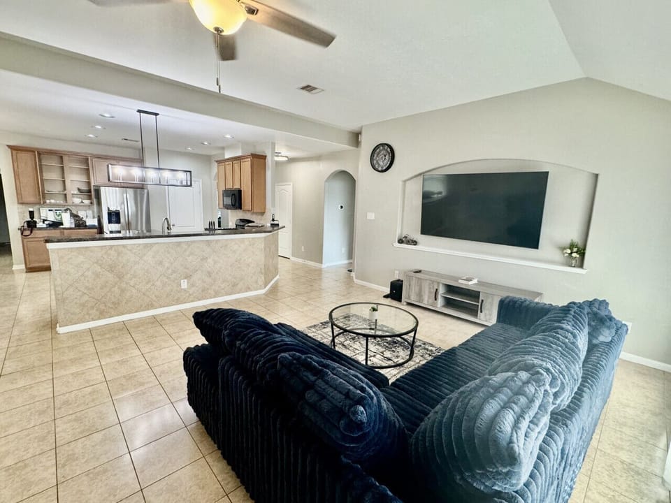 Bright open layout connecting the living room and kitchen — unwind on the plush sofa and enjoy movie nights in comfort.