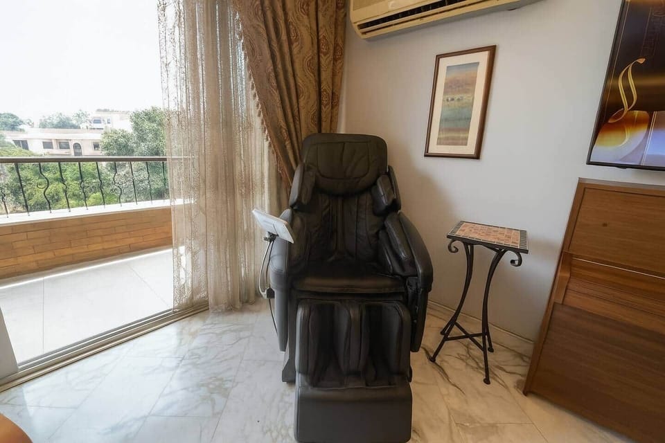 Relax in the full-body massage chair, perfectly placed by the balcony for comfort with a view.
