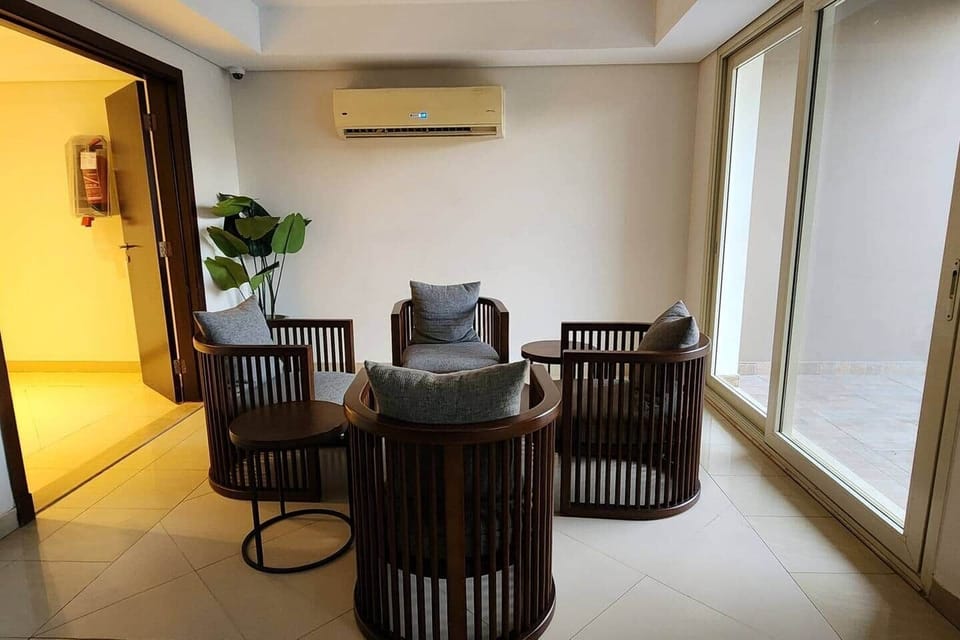 The community center, by the pool. A cozy and intimate lounge corner, perfect for morning coffee, quiet chats, or enjoying the view from the large sliding glass doors.