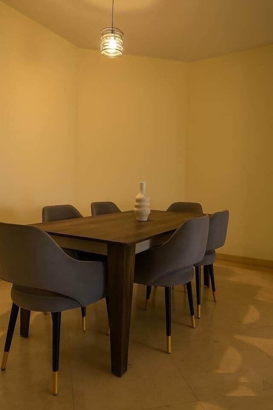 Elegant wood dining set with velvet chairs and warm ambient lighting for a cozy dining experience.

