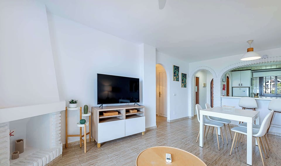 Experience the seamless flow of this beautifully designed open-plan living space that combines modern comfort with Mediterranean charm. The area features a fully equipped kitchen with breakfast bar seating, elegant dining space for four, and comfortable lounge area with flat-screen TV. Traditional archway details and contemporary furnishings create a perfect blend of old-world character and modern convenience, all enhanced by abundant natural light.