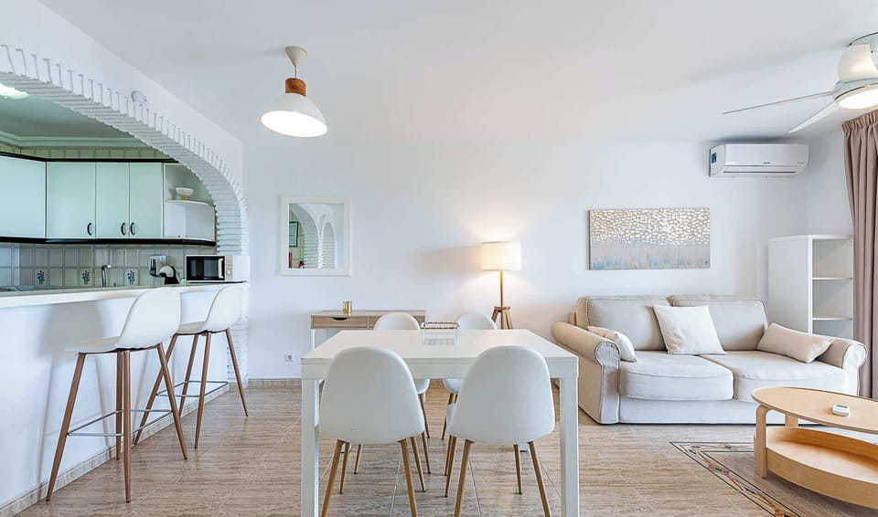 Discover the heart of this beautiful apartment in the open-plan kitchen and living area, where traditional Spanish architecture meets contemporary design. The fully equipped kitchen features modern appliances and breakfast bar seating, while the comfortable lounge and dining areas provide ample space for relaxation and entertaining. Elegant archway details, air conditioning ensure a home-away-from-home experience.