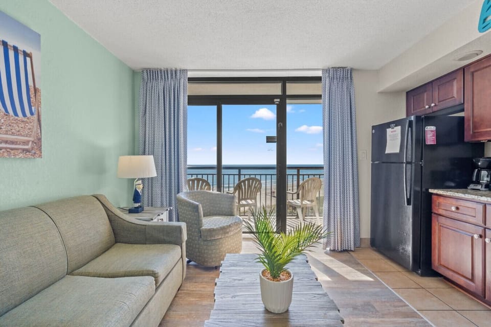 Beautiful oceanfront condo at Beach Cove Resort in North Myrtle Beach. Enjoy panoramic views of the Atlantic from floor-to-ceiling windows, coastal décor, and natural sunlight. The perfect spot to relax, unwind, and embrace your Myrtle Beach getaway.