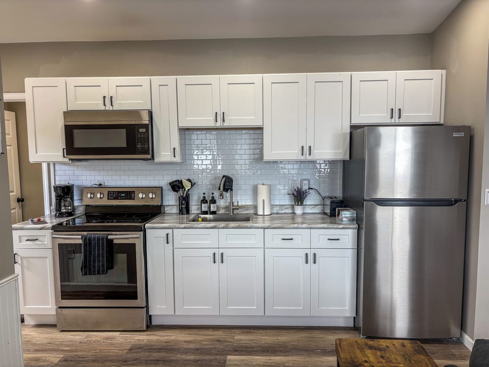 Modern kitchen with stainless appliances, bright finishes, and ample storage
